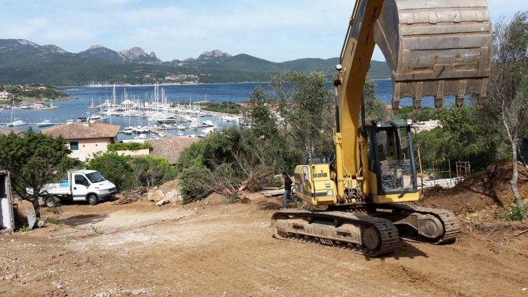pala meccanica mentre effettua una lavorazione su un campo