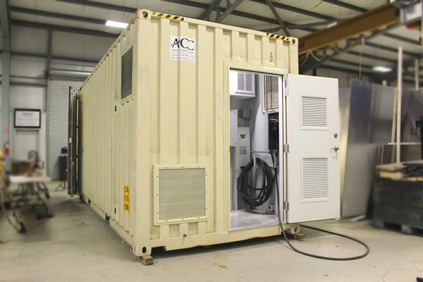 A shipping container is sitting in a building with the door open.