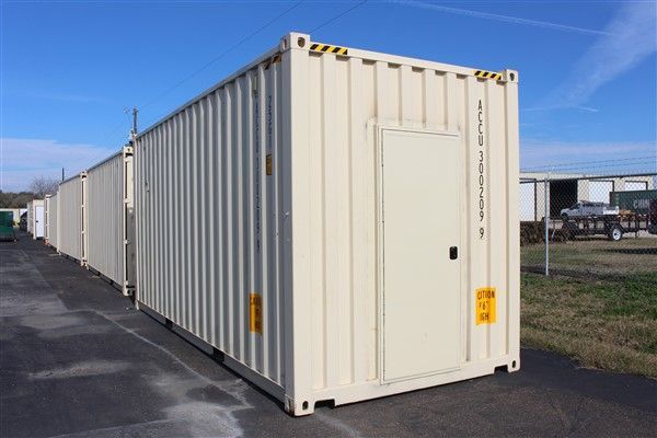 A row of shipping containers are lined up in a parking lot