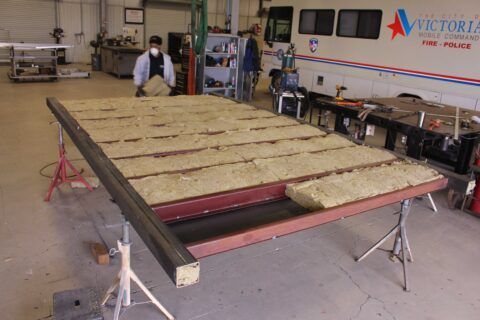 A victoria bus is being built in a garage