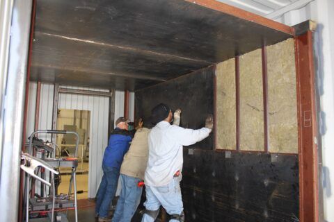 A group of men are working on a wall in a building
