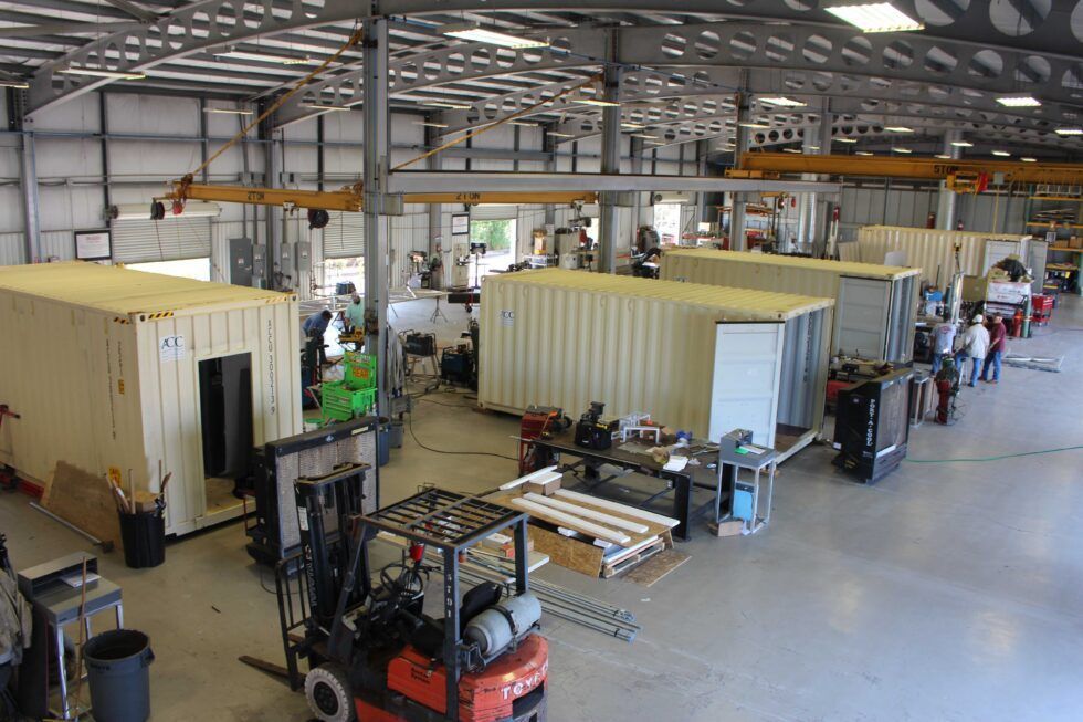 A large warehouse filled with lots of containers and a forklift.