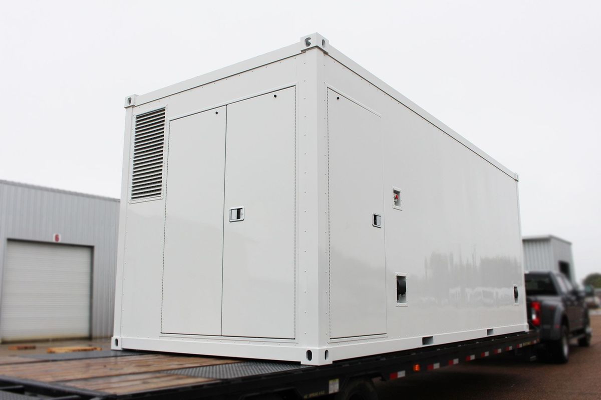 A large white container is sitting on top of a trailer.