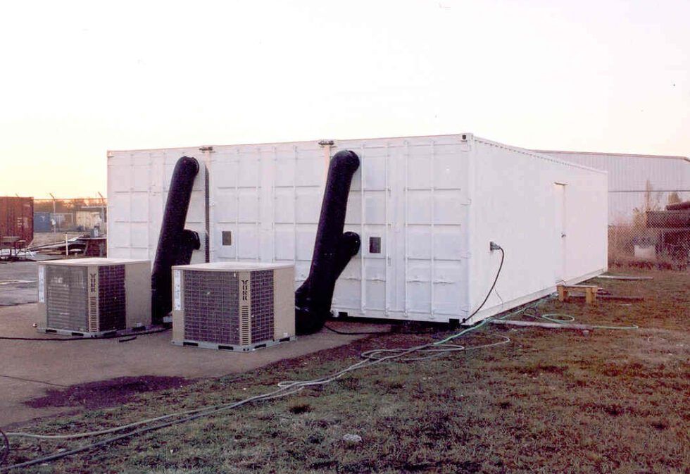 A large white building with two air conditioners attached to it.