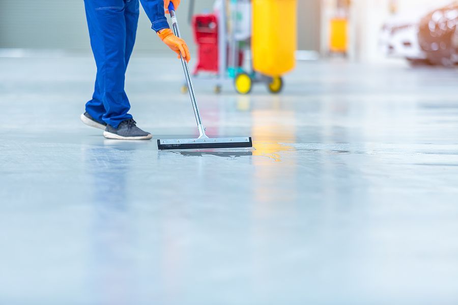 a person cleaning a floor with a mop