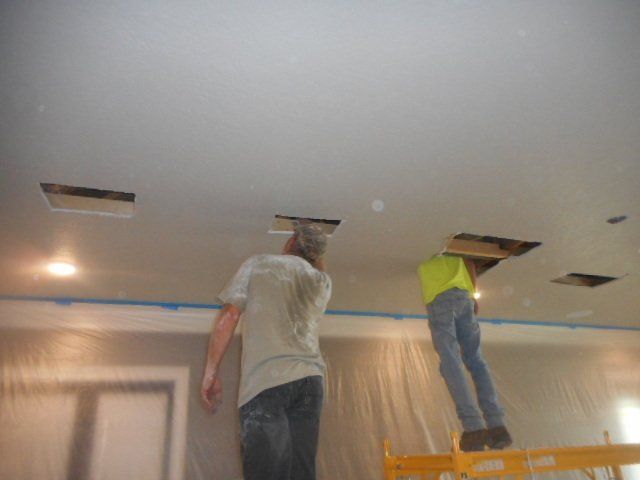 workers repairing damage in ceiling structure