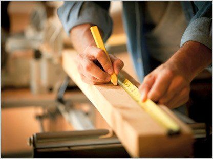 contractor measuring wood materials