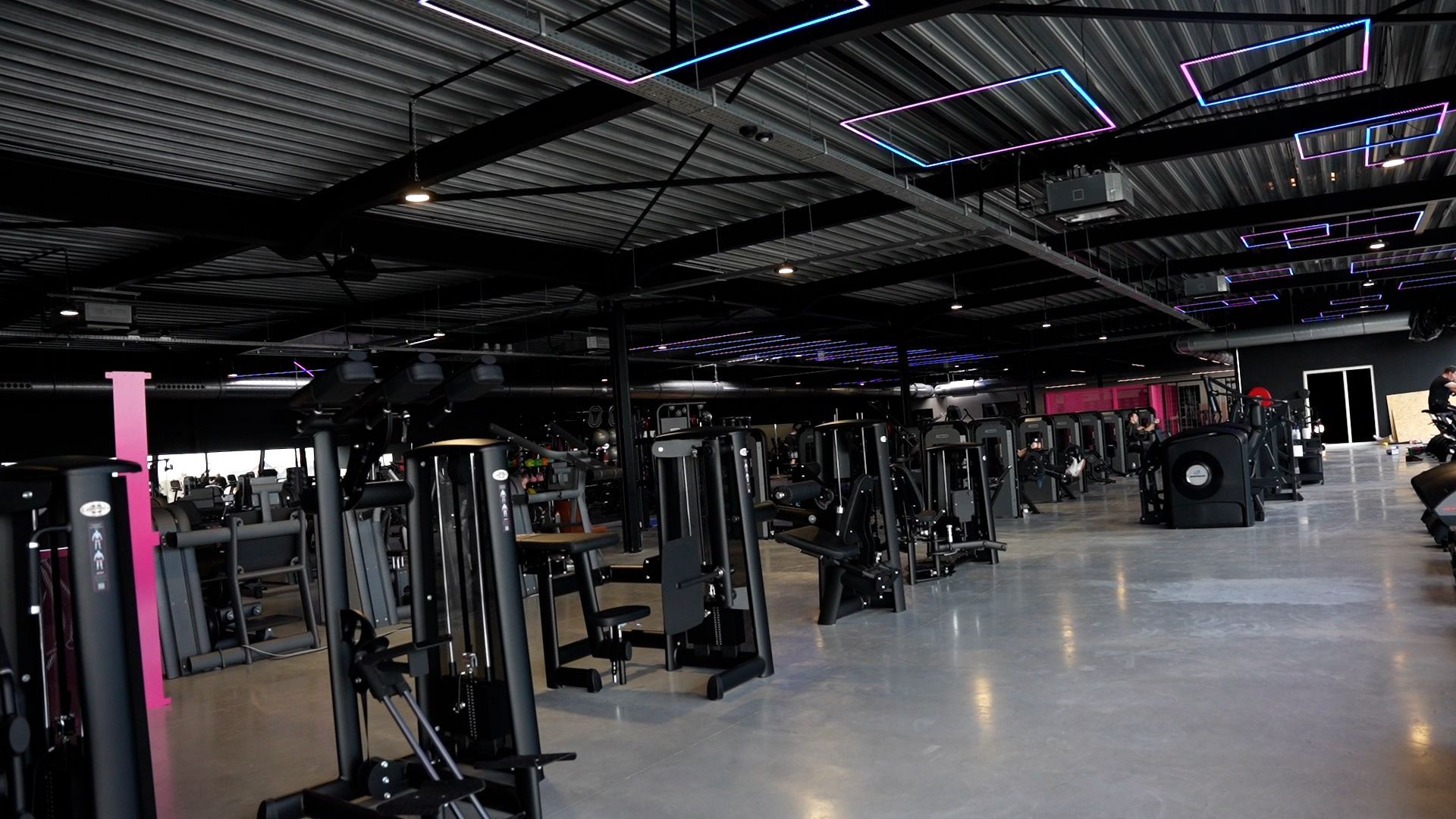 Een grote sportschool vol met fitnessapparatuur.