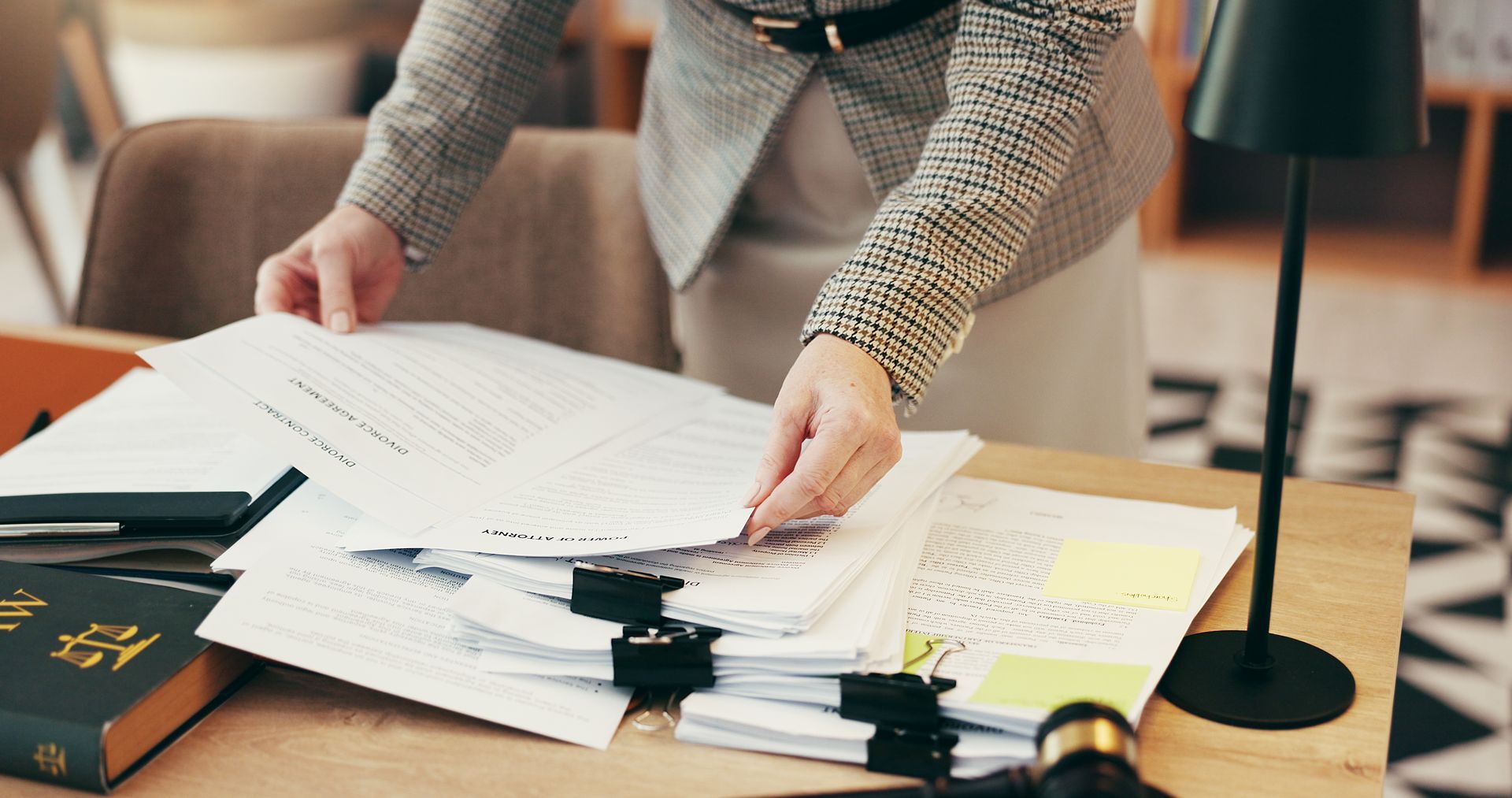 a woman standing over a pile of paperwork