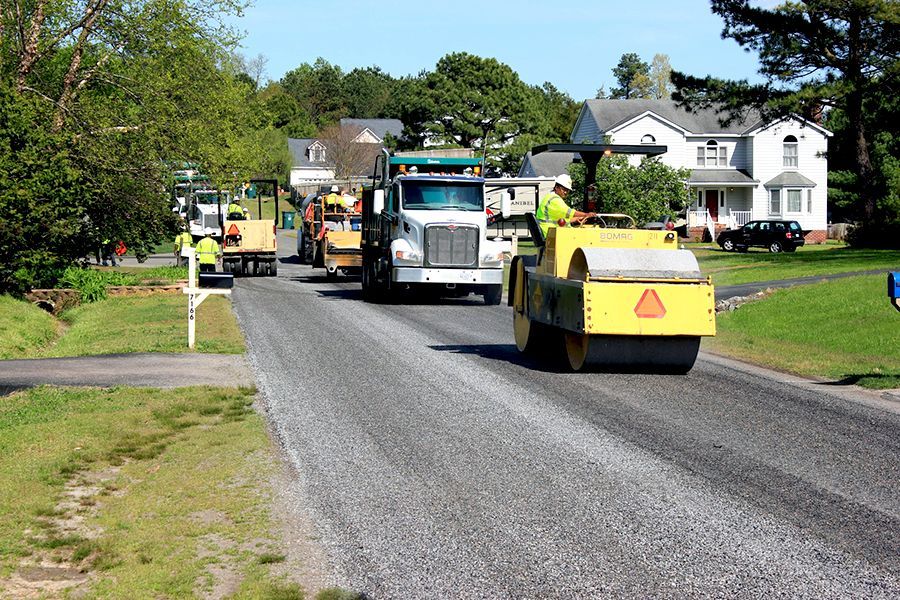 All chip seal equipment lined up working in a neighborhood.