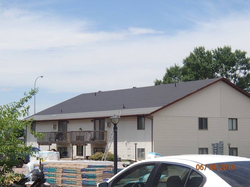 A white car is parked in front of a house