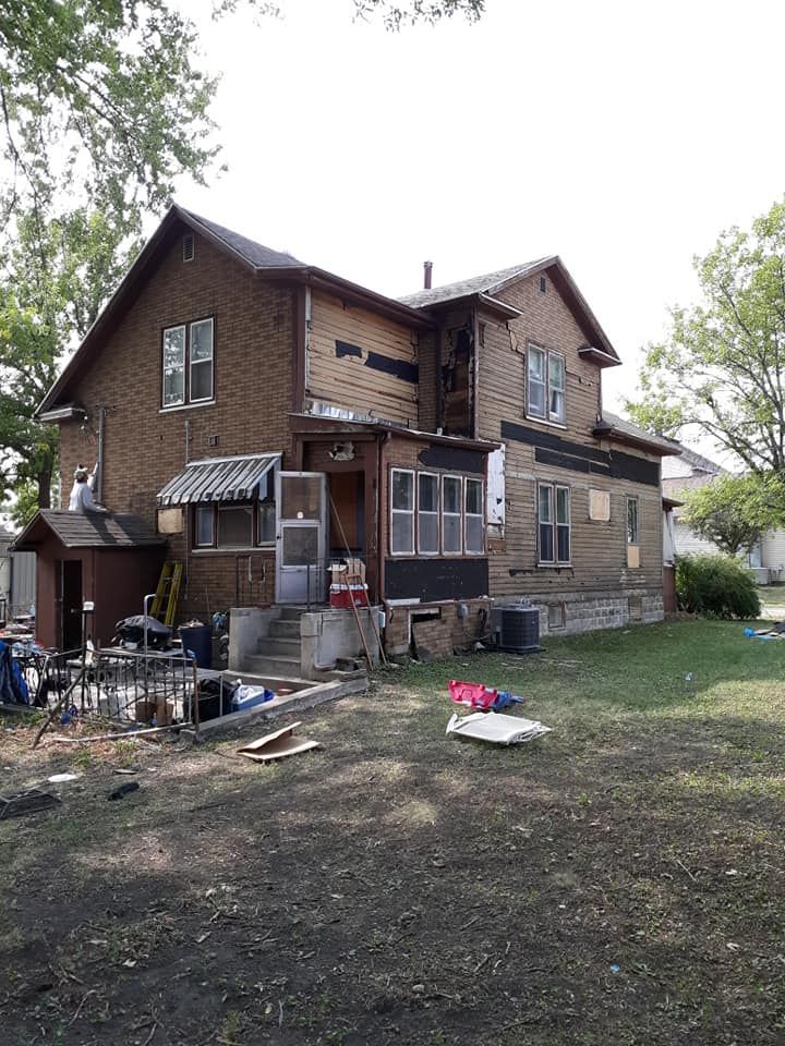 A large brick house with a lot of windows is being remodeled.