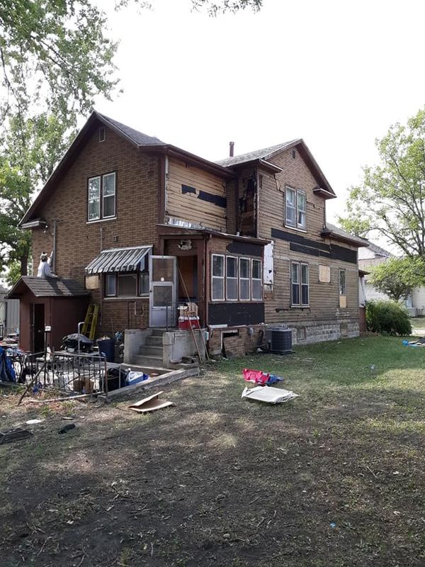 A large brick house with a lot of windows is being remodeled.