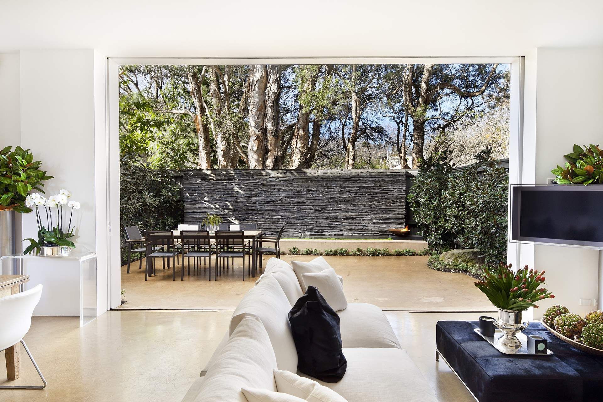 A living room with a white couch and a black ottoman