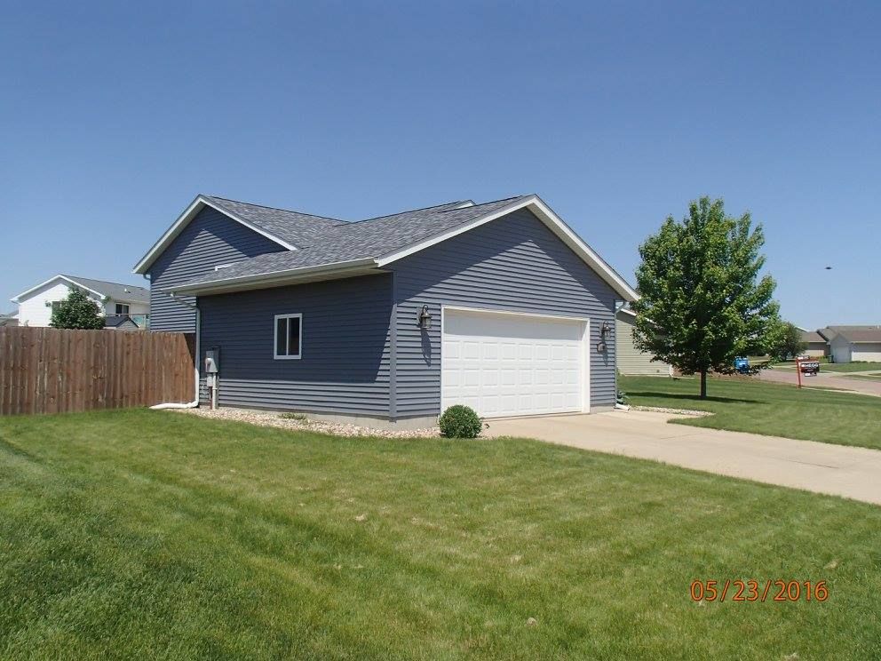 A house with a garage and a fence in front of it