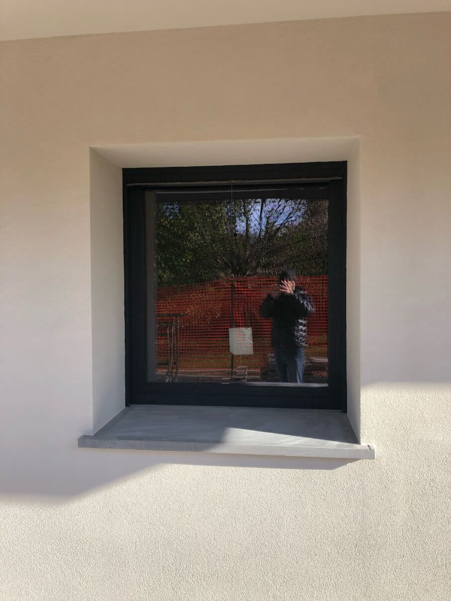 Un uomo è in piedi davanti alla finestra di un edificio.