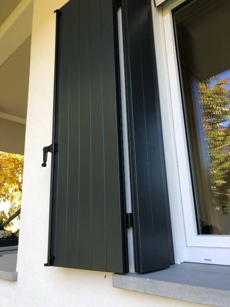 Una finestra bianca con persiane nere