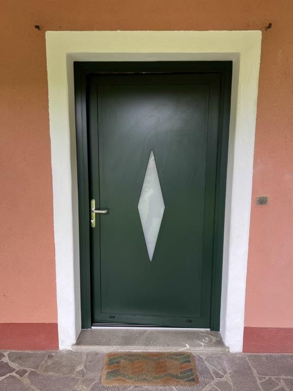 Una porta verde con un disegno a forma di diamante