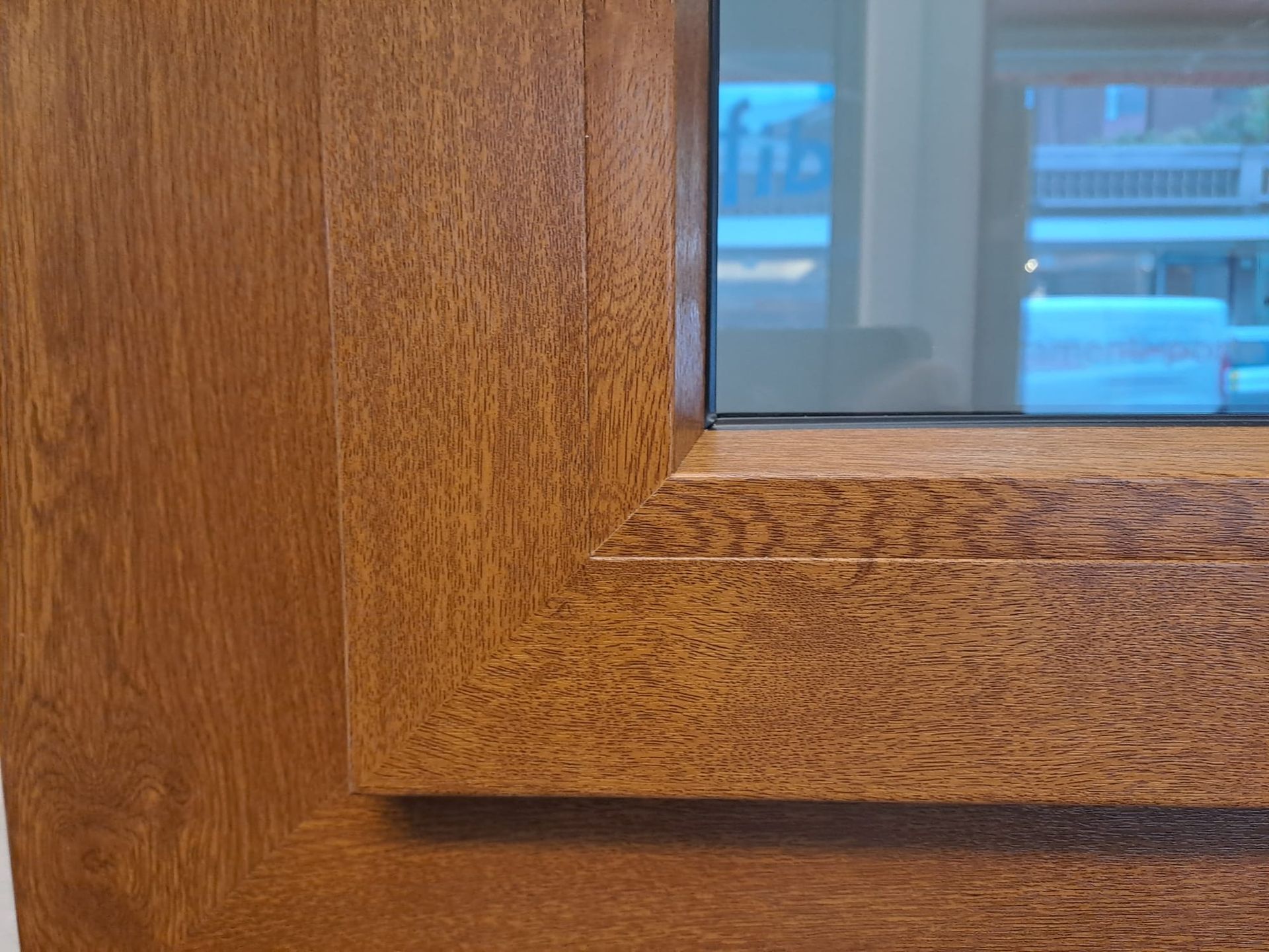 Un primo piano del telaio di una finestra in legno con una finestra in vetro.