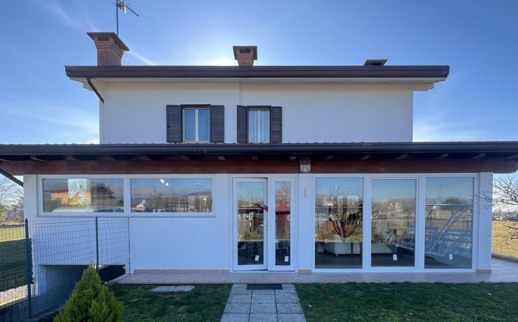 Una grande casa bianca con molte finestre e un passaggio pedonale che vi conduce.