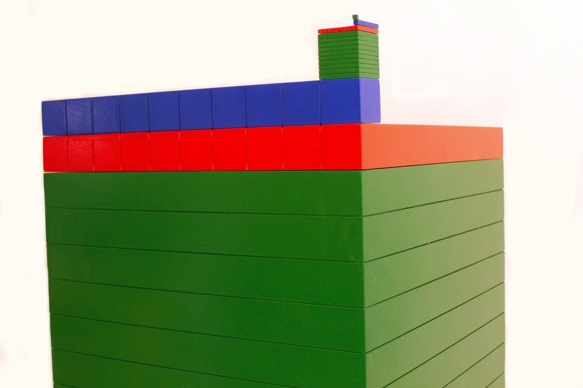 Stacked blocks of green, red, and blue colors. A taller tower on top with a single blue block on top.