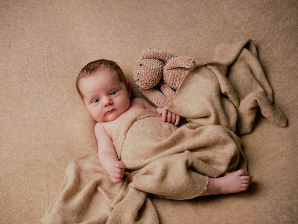 Een vrouw leunt tegen een boom, met haar haar wapperend in de wind.