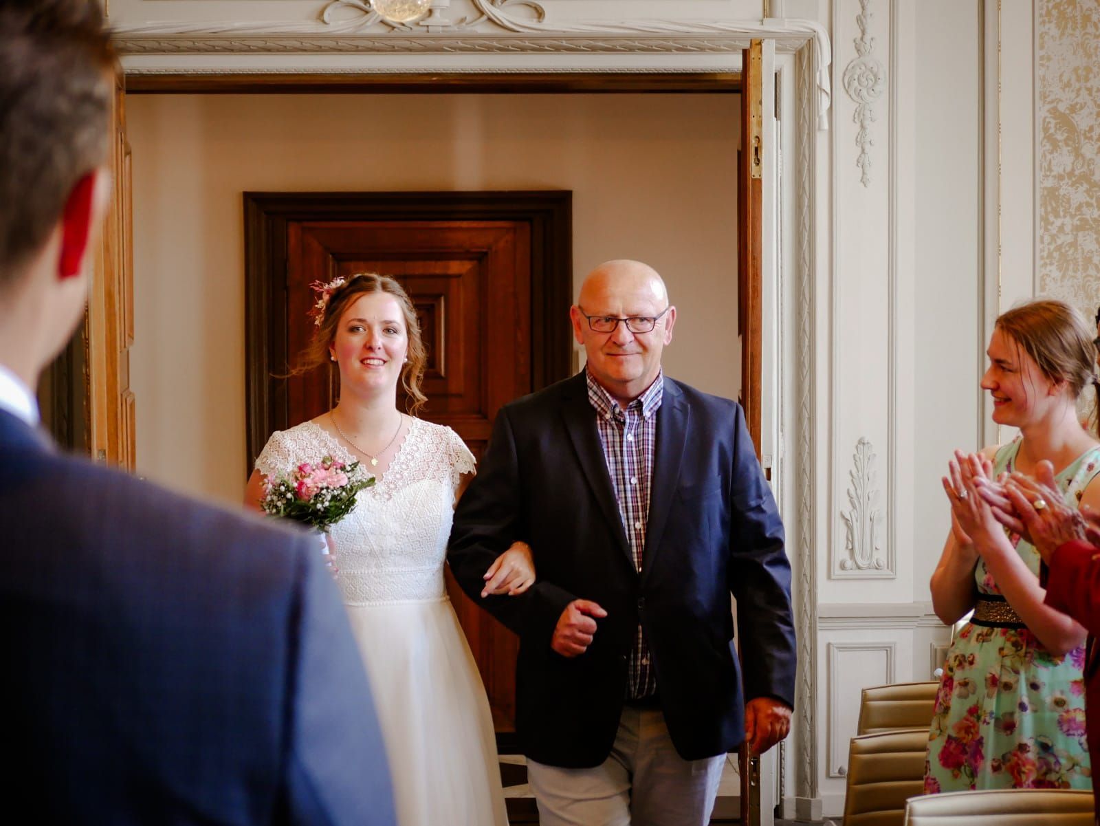 Een man begeleidt een bruid naar het altaar op een bruiloft.