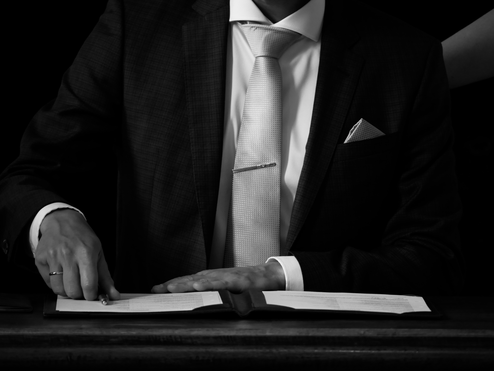Een man in pak en stropdas leest een boek