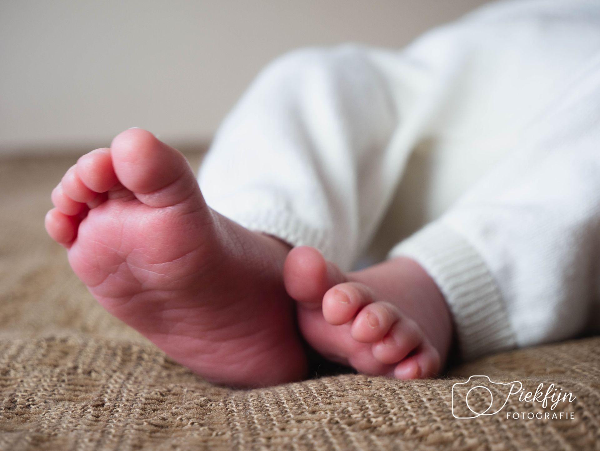 Een close-up van de voeten van een baby op een deken.