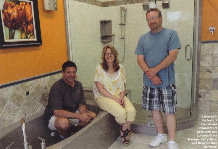 Interior view of a kitchen with a gray island, bar stools, and dark cabinets. A bouquet of roses sits on the island.