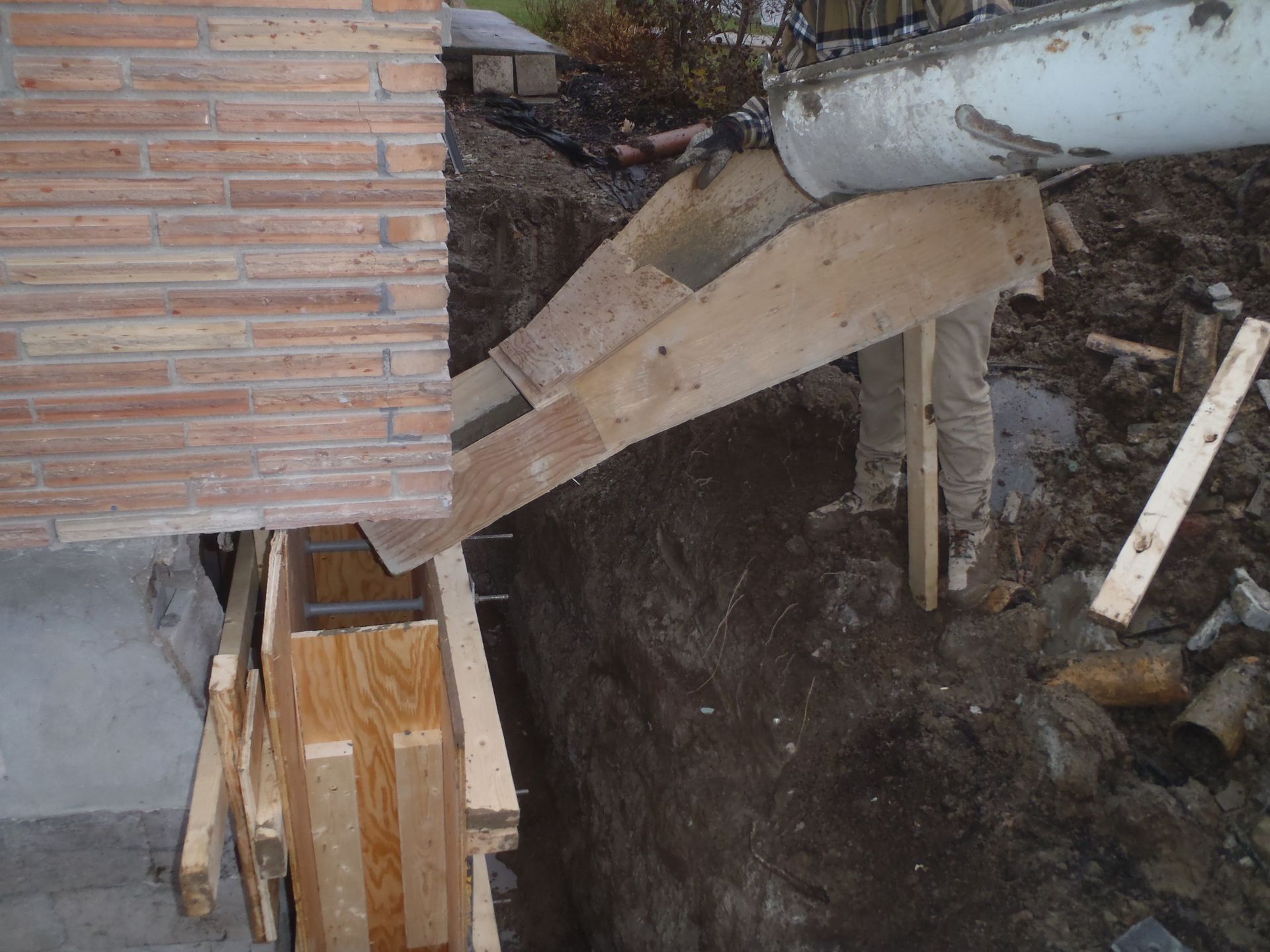 A brick wall is being built with wooden forms