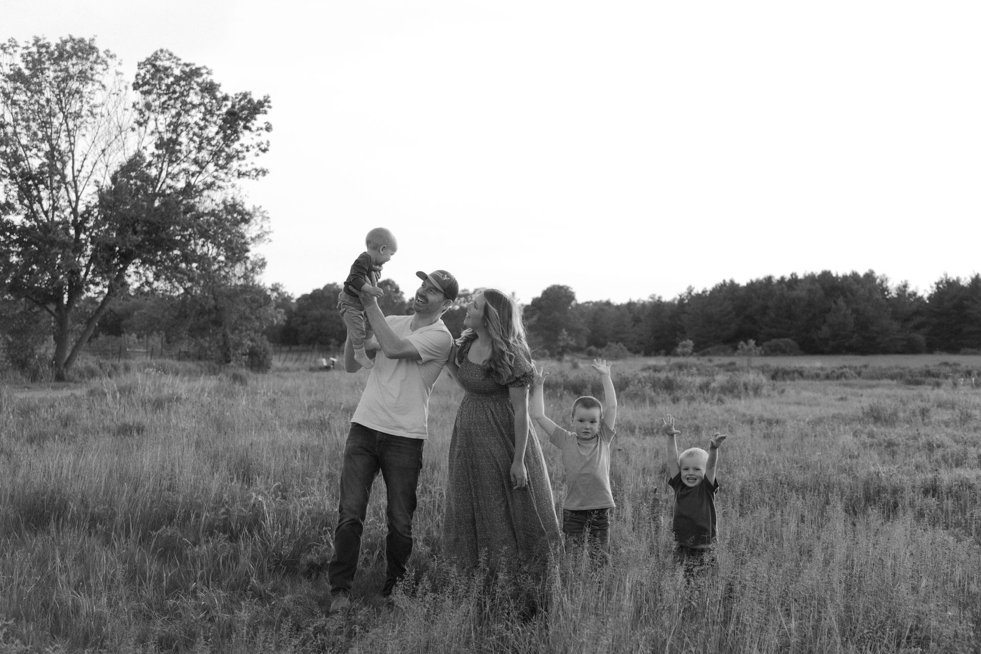 A black and white photo of a family standing in a field.