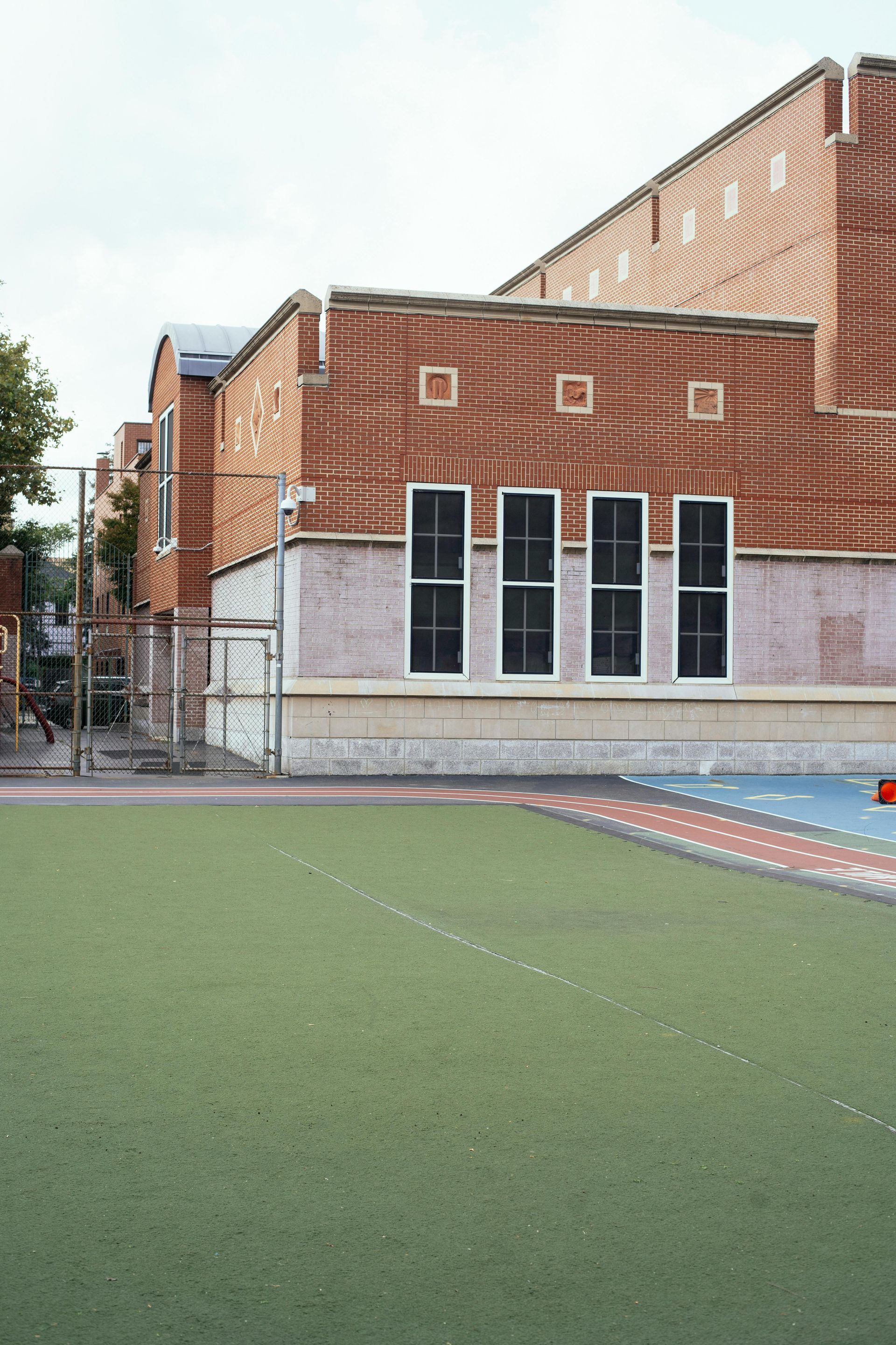 A brick building with a soccer field in front of it