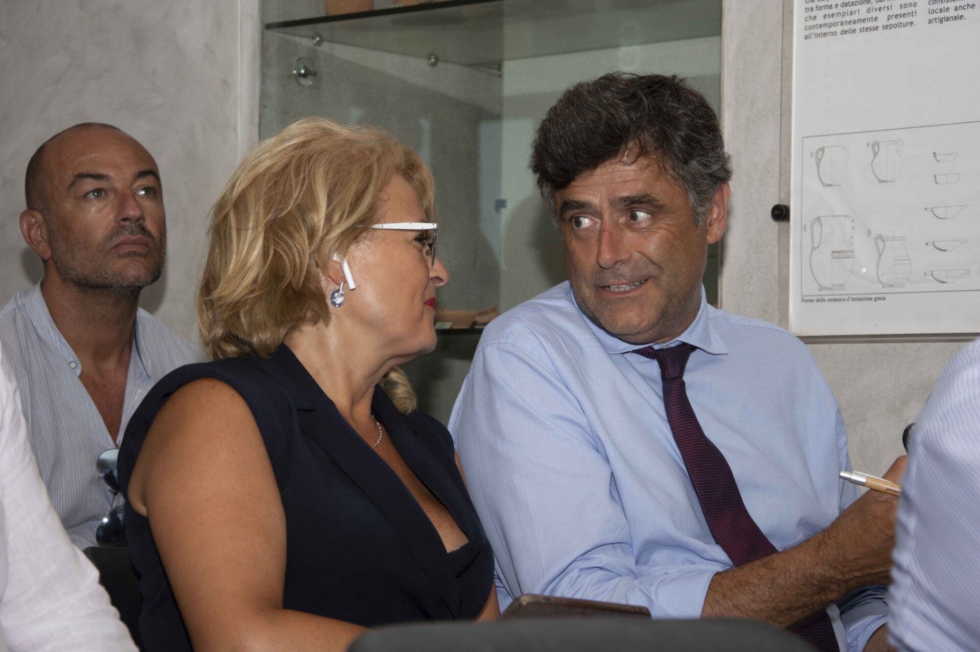 Un uomo e una donna sono seduti davanti a una lavagna bianca