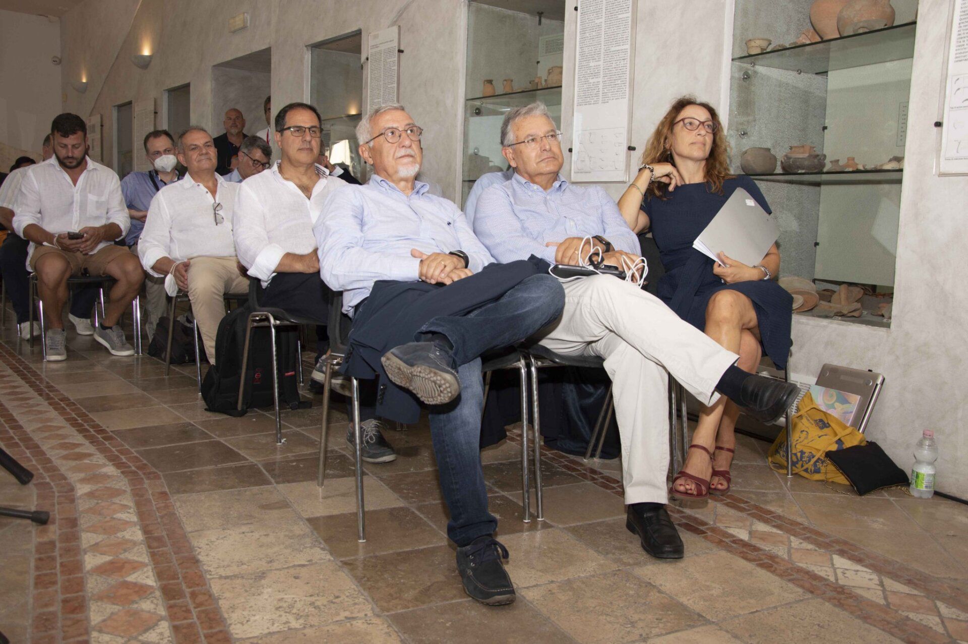 Un gruppo di persone è seduto su delle sedie in una stanza.