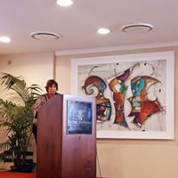 Una donna è in piedi su un podio davanti a un dipinto.