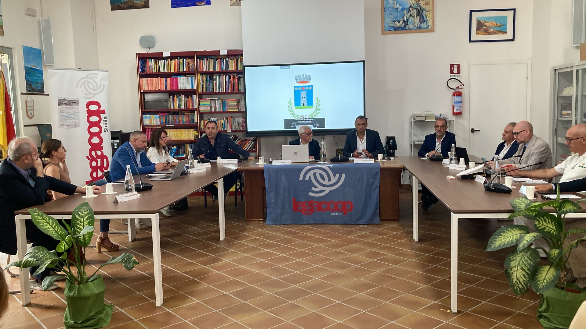 Un gruppo di persone è seduto attorno a un lungo tavolo in una stanza.