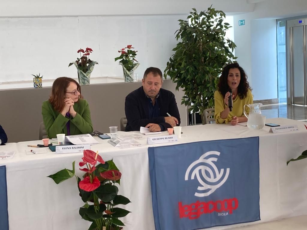 Un gruppo di persone è seduto a un tavolo con uno striscione che dice bg group