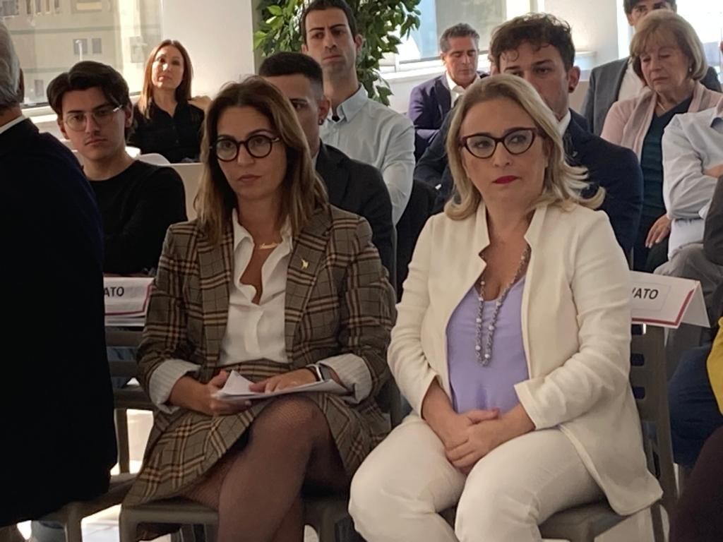 Un gruppo di persone è seduto su delle sedie in una stanza.