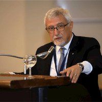 Un uomo in giacca e cravatta è in piedi su un podio e sta tenendo un discorso.