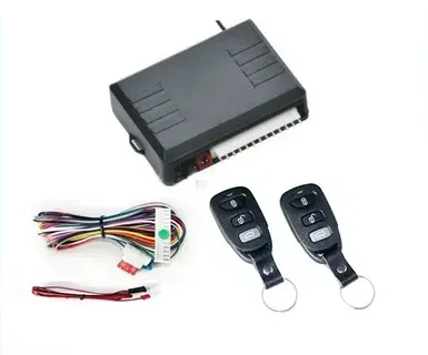 Car remote keyless entry system with two key fobs, wiring harness, and a control module on a white surface.