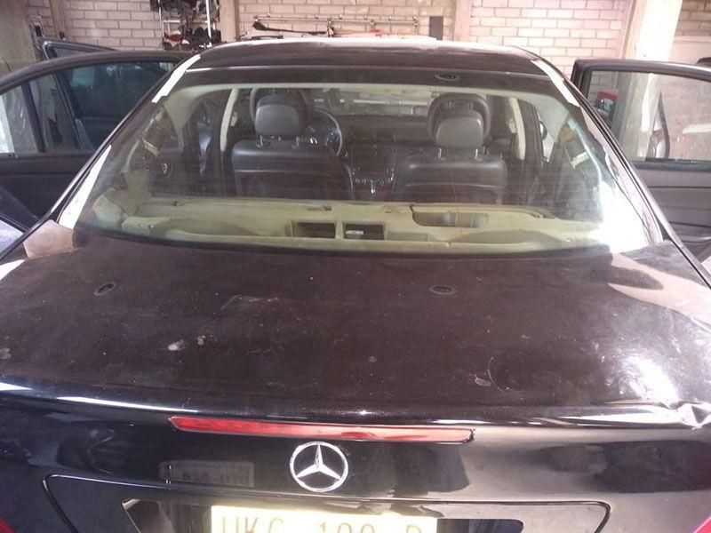 Un Mercedes negro está estacionado en un garaje.
