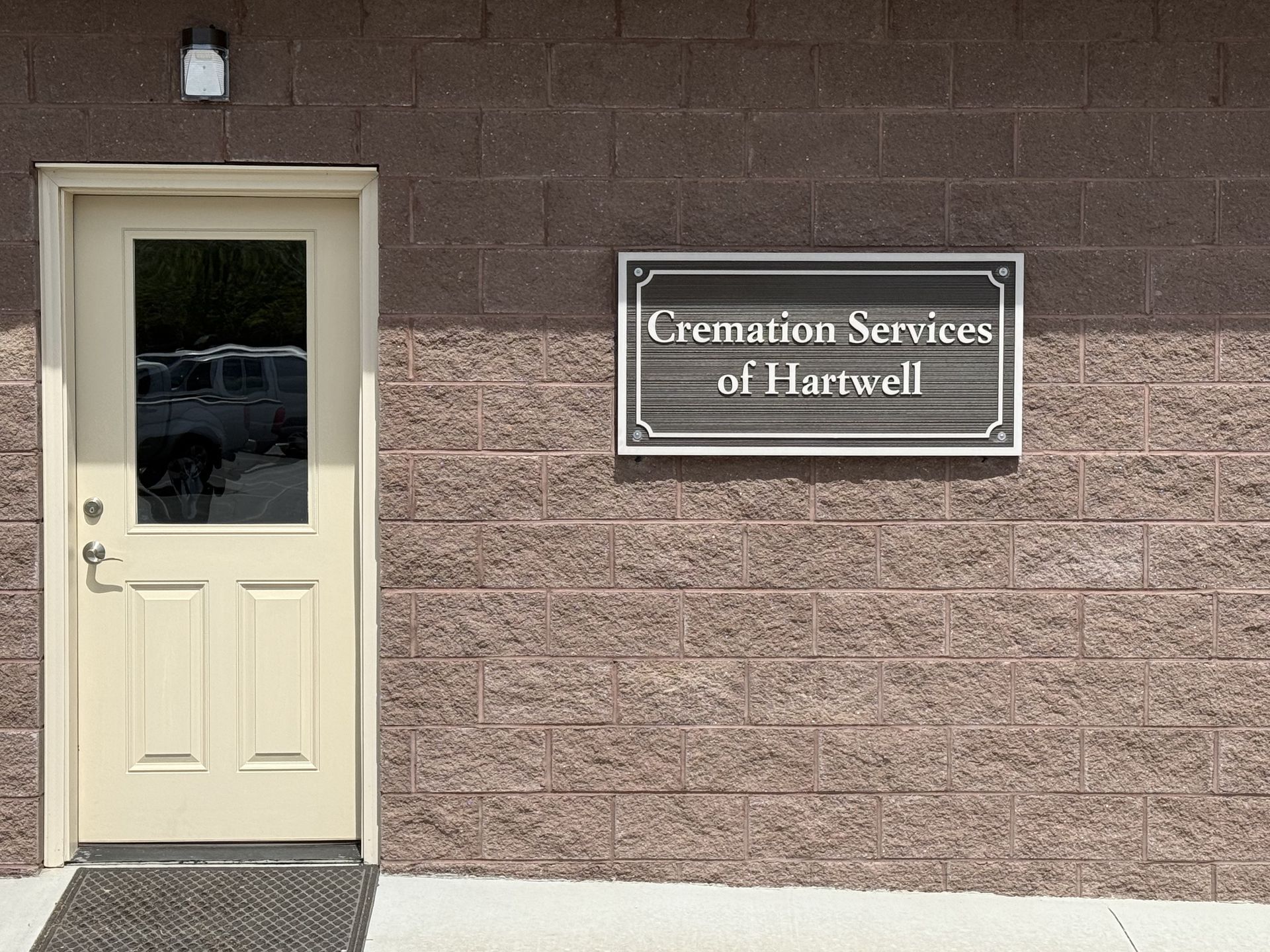 Sign for Strickland Funeral Home & Cremation Services; brown brick, wooden sign.