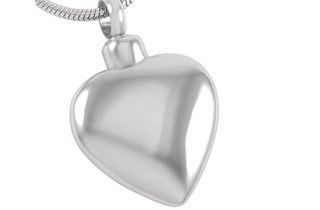 Silver heart-shaped cremation pendant with a small opening at the top, hanging from a silver chain.