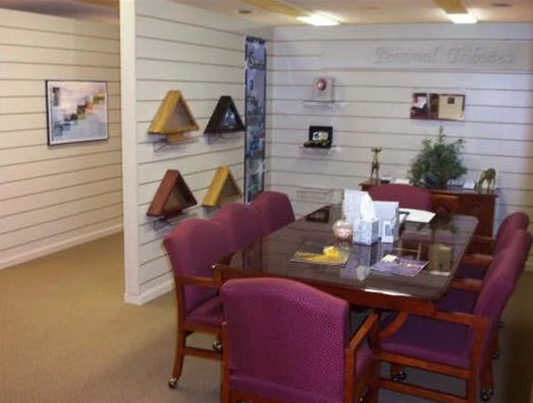 A conference room with a table, chairs, decorations, and artwork on the walls.