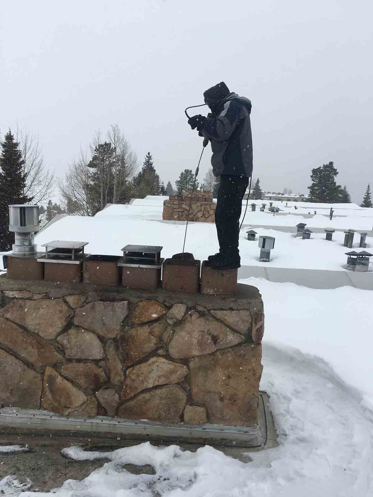 Fireplace Maintenance — Man at the Top of Chimney in Silverthorne, CO