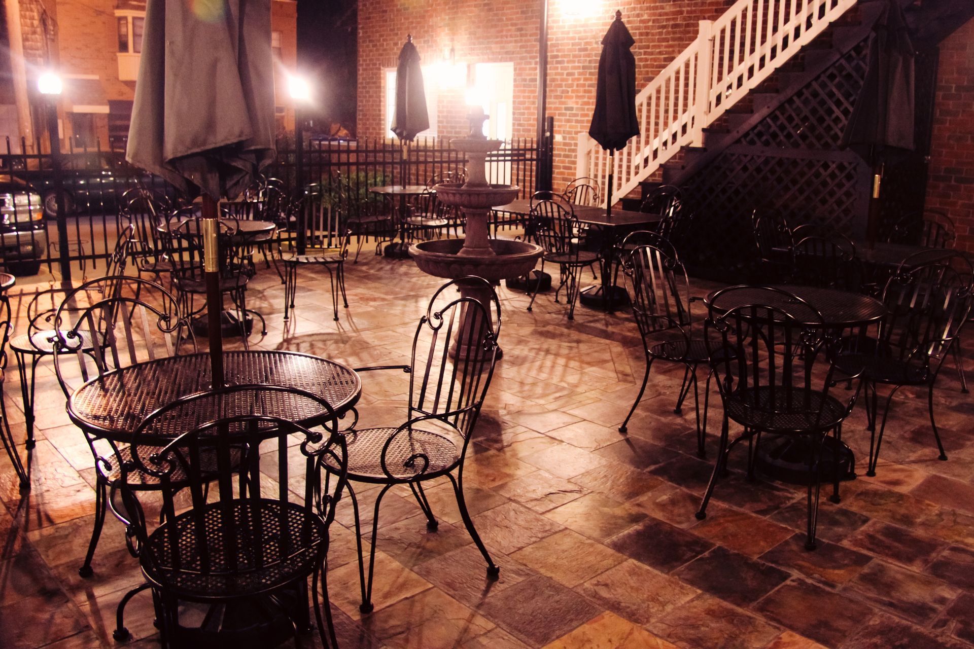 A patio with tables and chairs and umbrellas at night