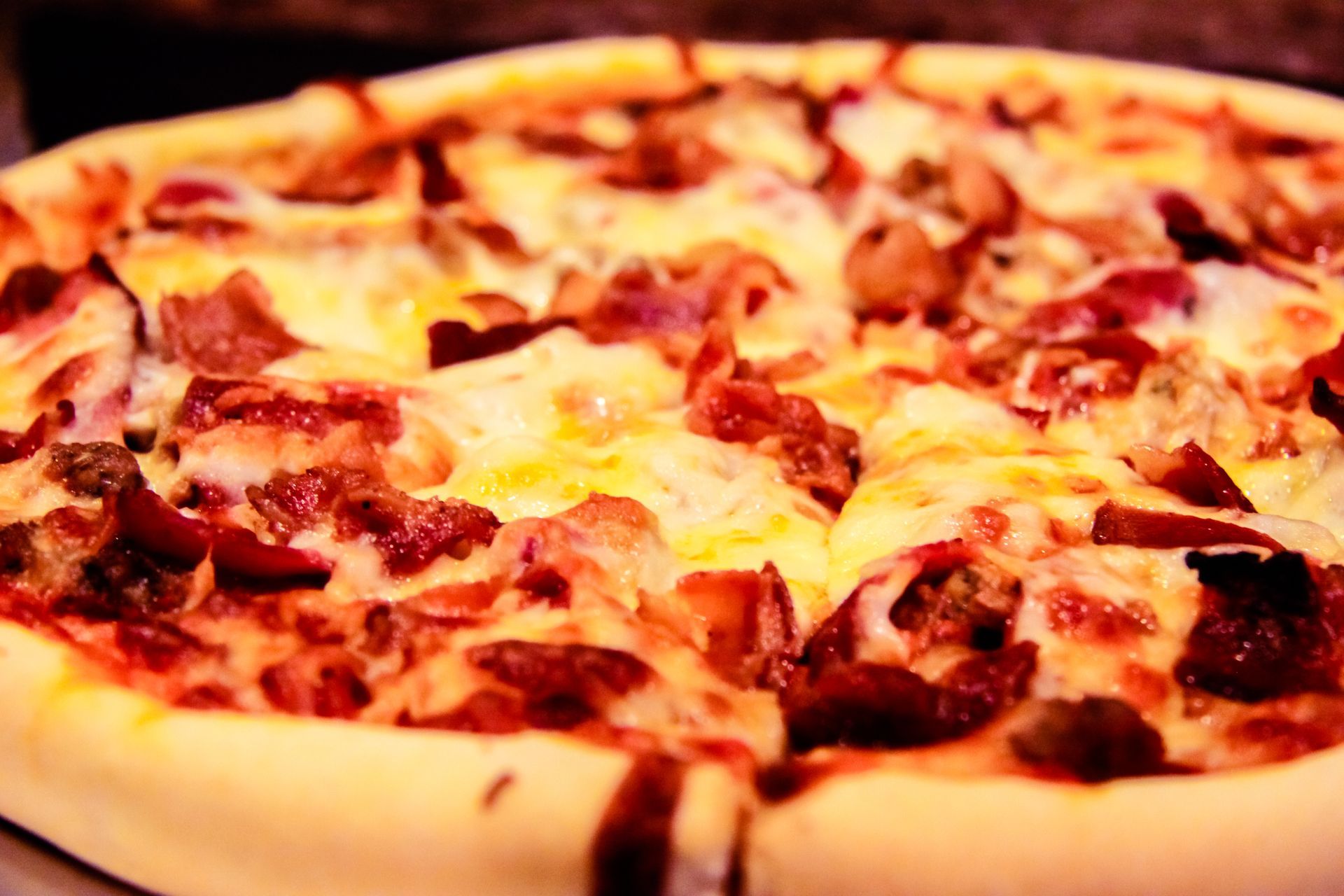 Pizza with sausage, cheese and bacon