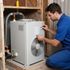 Certified Comfort of Georgia technician working on an older HVAC unit in a customer's basement