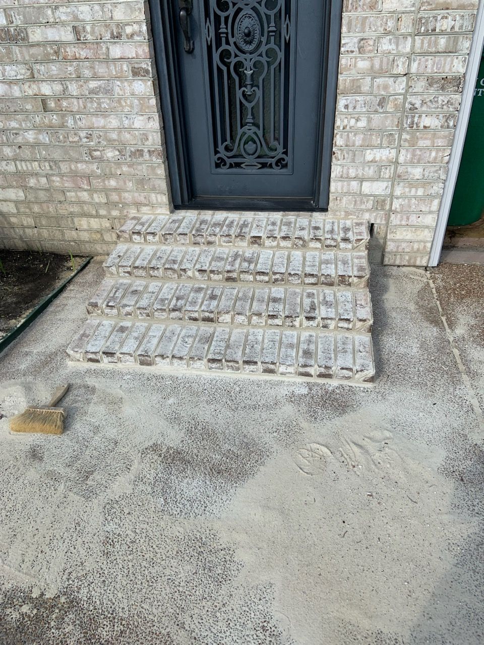 A brick building with a black door and steps.